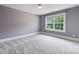 Bedroom with gray walls, carpet flooring, and a window view at 2844 Georgia Ave, Charlotte, NC 28205