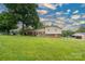 Backyard view of the home featuring a large grassy area and mature trees at 318 Confederate Sw Dr, Concord, NC 28027