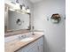 Cozy bathroom with a marble countertop, decorative mirror, hexagon wall decor, and vanity lighting at 318 Confederate Sw Dr, Concord, NC 28027