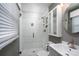 Modern bathroom featuring a tiled glass shower enclosure, a white vanity, and a round mirror at 318 Confederate Sw Dr, Concord, NC 28027