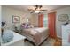 Charming bedroom with floral wallpaper, hardwood floors, pink curtains, and a ceiling fan at 318 Confederate Sw Dr, Concord, NC 28027