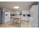 Bright kitchen with tile floors, wooden island, and white cabinets with modern appliances at 318 Confederate Sw Dr, Concord, NC 28027