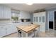 Bright kitchen with tile floors, wooden island, and white cabinets with modern appliances at 318 Confederate Sw Dr, Concord, NC 28027