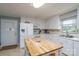 All-white kitchen featuring tile floors, island, and stainless steel appliances at 318 Confederate Sw Dr, Concord, NC 28027