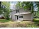 View of backyard and house, showing back patio, siding, chimney and mature trees at 3826 Yorkford Dr, Charlotte, NC 28269