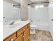 A clean bathroom featuring wooden cabinets, a white tub, shower and toilet at 3826 Yorkford Dr, Charlotte, NC 28269