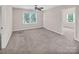 Spacious bedroom with neutral walls and carpet, ceiling fan, and view of the yard through the window at 3826 Yorkford Dr, Charlotte, NC 28269