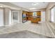 A wide angle shot of a kitchen with oak cabinets and tile floors opening up to a living room at 3826 Yorkford Dr, Charlotte, NC 28269