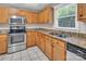 A well lit kitchen featuring oak cabinets and granite countertops, as well as stainless steel appliances at 3826 Yorkford Dr, Charlotte, NC 28269