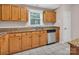 An oak kitchen with granite countertops and a stainless steel dishwasher and sink at 3826 Yorkford Dr, Charlotte, NC 28269