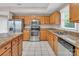 Well-lit kitchen featuring oak cabinets, granite countertops, stainless steel appliances, and a kitchen island at 3826 Yorkford Dr, Charlotte, NC 28269