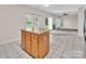 An oak kitchen island with granite countertops next to a carpeted living room space at 3826 Yorkford Dr, Charlotte, NC 28269