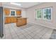 A kitchen with oak cabinets, a kitchen island and tile flooring and two large windows at 3826 Yorkford Dr, Charlotte, NC 28269