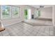 A bright living room with three windows and sliding glass door and tan carpet flooring at 3826 Yorkford Dr, Charlotte, NC 28269