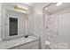 Bathroom with granite counter, single sink, large mirror, and a shower with glass doors at 409 W 8Th St, Charlotte, NC 28202