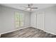Cozy bedroom with wood-look floors, ceiling fan, large window, and spacious closet at 409 W 8Th St, Charlotte, NC 28202