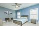 Comfortable bedroom with blue walls, a wooden bed frame, a fan, and natural light from the window at 424 Cassia Ct, Fort Mill, SC 29708