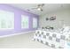 Bright bedroom with a modern ceiling fan, natural lighting, and a decorative purple accent wall at 424 Cassia Ct, Fort Mill, SC 29708
