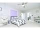 Comfortable bedroom with a ceiling fan, decorated accent wall, a cozy hammock chair, and a view into the bathroom at 424 Cassia Ct, Fort Mill, SC 29708