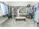 Spacious walk-in closet with custom shelving for shoes and clothes, and a comfortable bench in the center at 424 Cassia Ct, Fort Mill, SC 29708