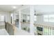 Bright open hallway showcasing iron railing and views into other rooms with ceiling fans and natural light at 424 Cassia Ct, Fort Mill, SC 29708