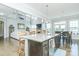 Kitchen island with barstool seating and stainless steel sink overlooking living area at 424 Cassia Ct, Fort Mill, SC 29708