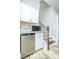 Compact kitchenette featuring white cabinets, stainless steel appliances, and adjacent staircase at 424 Cassia Ct, Fort Mill, SC 29708