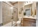Full bathroom with a tiled shower, wood vanity, and decorative wall art at 4511 Middlebury Ln, Fort Mill, SC 29715