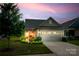 Inviting home showcasing meticulous landscaping, an attached two-car garage, and a cozy front porch at 4511 Middlebury Ln, Fort Mill, SC 29715