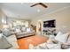 Open-concept living room with a sofa, a ceiling fan, a mounted TV, and a connection to the kitchen at 4511 Middlebury Ln, Fort Mill, SC 29715