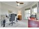 Home office with a gray chair, desk, and two windows with natural light and views of the backyard at 4511 Middlebury Ln, Fort Mill, SC 29715