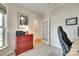 Home office featuring a gray chair, a red cabinet, artwork, and a doorway at 4511 Middlebury Ln, Fort Mill, SC 29715
