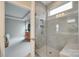 Modern tiled shower with glass door, built-in shelf, and overhead window at 4511 Middlebury Ln, Fort Mill, SC 29715