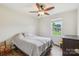 This cozy bedroom features hardwood floors, a ceiling fan, and a bright window at 4527 Marshall Ct, Monroe, NC 28110