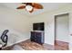 Comfortable bedroom with hardwood floors, ceiling fan, access to another room, and a TV at 4527 Marshall Ct, Monroe, NC 28110