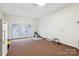 Large bonus room with brown carpet, access to the backyard, and great natural light at 4527 Marshall Ct, Monroe, NC 28110