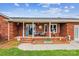 Cozy front porch of a brick home, featuring a welcoming seating area and charming decor at 4527 Marshall Ct, Monroe, NC 28110