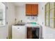 Bright laundry room features modern washer and dryer, upper cabinets, and doors at 4527 Marshall Ct, Monroe, NC 28110