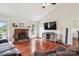 Cozy living room with brick fireplace, hardwood floors, and a large TV for entertaining at 4527 Marshall Ct, Monroe, NC 28110