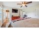 Cozy main bedroom with hardwood floors, ceiling fan, TV, and access to the ensuite bathroom at 4527 Marshall Ct, Monroe, NC 28110