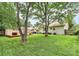 Expansive backyard featuring lush green grass, mature trees, and a charming deck area for outdoor relaxation at 5929 Brookhaven Rd, Charlotte, NC 28210