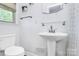 Bright bathroom featuring a pedestal sink and a window at 5929 Brookhaven Rd, Charlotte, NC 28210