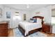 Cozy bedroom boasts hardwood floors, neutral walls, a ceiling fan and a large window at 5929 Brookhaven Rd, Charlotte, NC 28210