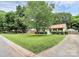 Property featuring a spacious front lawn with mature trees, enhanced curb appeal, and a welcoming atmosphere at 5929 Brookhaven Rd, Charlotte, NC 28210