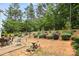 Spacious backyard featuring mature trees, manicured landscaping, and patio seating at 6010 Hawk View Rd, Waxhaw, NC 28173