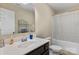 Bright bathroom featuring a sleek vanity with a large mirror and a combined bathtub and shower at 6010 Hawk View Rd, Waxhaw, NC 28173