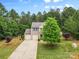 Lovely exterior view of a two-story home with beautiful trees and landscaping, including a long driveway at 6010 Hawk View Rd, Waxhaw, NC 28173