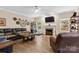 A spacious living room with a fireplace, a ceiling fan, and large windows for natural light at 6010 Hawk View Rd, Waxhaw, NC 28173