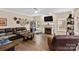 A spacious living room with a fireplace, a ceiling fan, and large windows for natural light at 6010 Hawk View Rd, Waxhaw, NC 28173