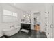 Modern bathroom with a soaking tub, walk-in shower, and sleek black and white vanity at 6013 Camile Ct, Charlotte, NC 28226